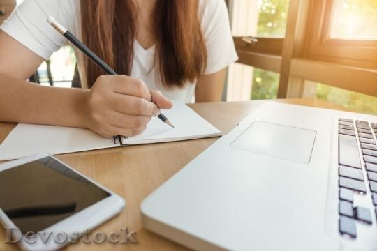 Stock photo female student taking notes from a book at library young asian 31531